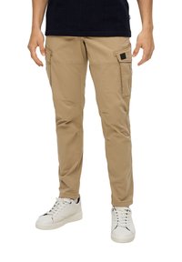 Beige cargo broek met meerdere zakken en een rechte pijpdesign, gemaakt van lichtgewicht stof. Draagt met witte sneakers.