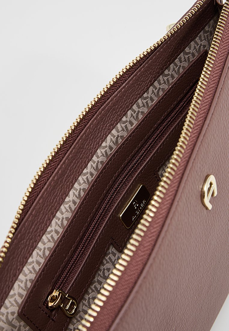 Braune, strukturierte Lederhandtasche mit Innenfutter in Gold, das ein gemustertes Futter und eine kleine, mit Reißverschluss verschlossene Tasche enthält.