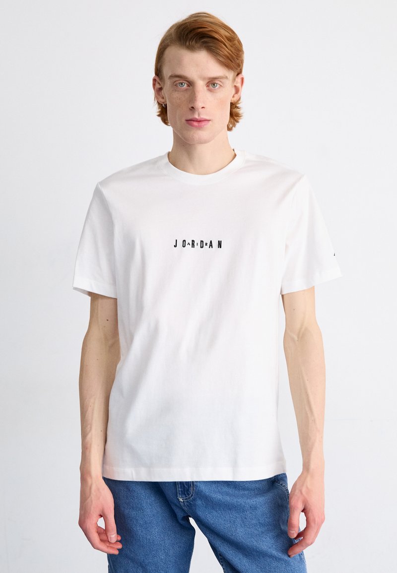 Fehér, rövid ujjú pamut póló, kerek nyakkivágással. A mellkason fekete színben szerepel a "JORDAN" felirat. Sima textúra.