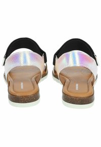 Achteraanzicht van sandalen met een gestructureerde, holografische band, een bruine, gevoerde voetbed en een witte rubberen zool met een kurkachtige textuur.