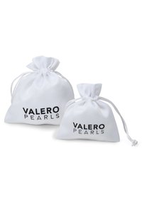 Två vita tygpåsar med dragsko, en större och en mindre, med texten "VALERO PEARLS" i svart. Slät textur, enkel design.
