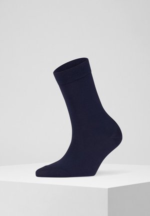 Granatowa skarpetka do kostki z ribbowanym mankietem, gładką teksturą i dopasowanym kształtem. Wykonana z rozciągliwego materiału dla wygody i trwałości.