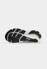 Suola di una scarpa da corsa Brooks Glycerin 6TS con motivo della suola nera e bianca su sfondo bianco.