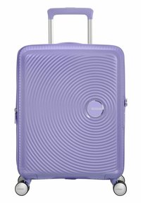 Valigia rigida di colore lavanda, con un motivo a onde testurizzate, logo argentato, manico telescopico e quattro ruote girevoli multicolori.