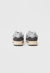 Baskets New Balance bleu et gris avec un mélange de matériaux en suède et en maille, dotées d'un semelle intermédiaire de couleur claire et d'une semelle extérieure noire.