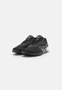 Black athletic shoes with a mesh upper, textured sole, and grey accents. Features white three-stripe design on the side and lace-up closure.
