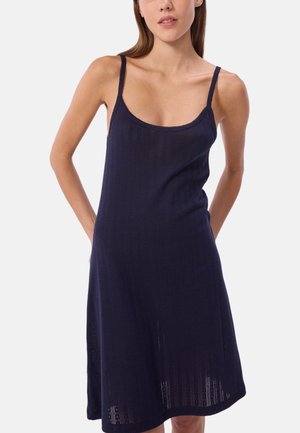 Navyblauw ribbel tankjurk met dunne bandjes, zachte textuur en een knielange silhouette, met kantaccenten langs de halslijn.