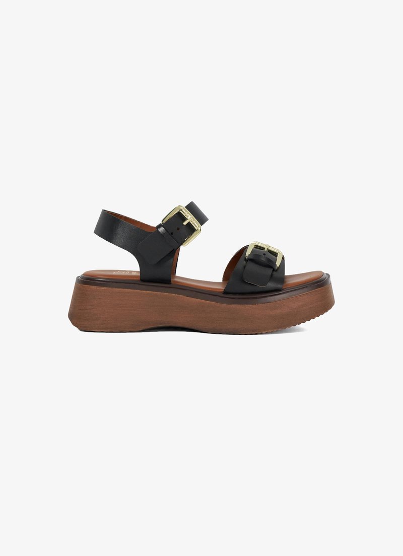 Black leather platform sandals with two gold-buckle accents, brown wooden sole, open toe design, and adjustable ankle straps.