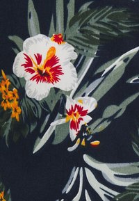 Blumenstoff mit großen weißen Blumen, die rote und gelbe Akzente setzen, umgeben von grünen Blättern und kleineren orangefarbenen Blumen, auf einem dunklen Hintergrund.