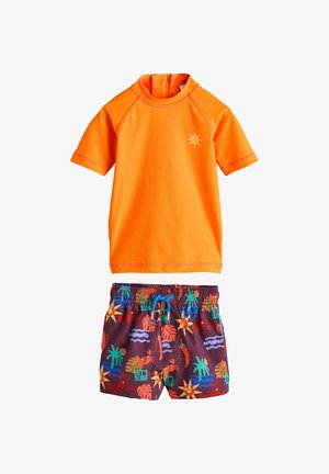 Ryškiai oranžinė trumpomis rankovėmis apsauginė marškinėliai su saulės logotipu, derinami su tamsiais maudymosi šortais, kuriuose yra spalvingi tropinių ir banglenčių tematikos raštai.