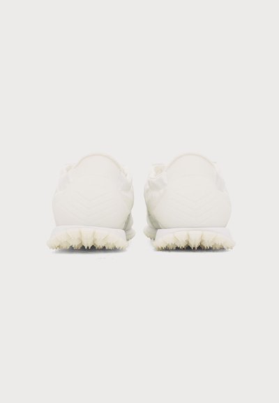 Paire de chaussures de sport blanches vues de dos avec des semelles texturées sur un fond blanc uni.