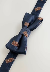 Tamsiai mėlynas peteliškės kaklaraištis su banguota tekstūra, puoštas mažais rudos spalvos gyvūnų piešiniais. Peteliškė tvarkingai suformuota, turi centrinį mazgą.