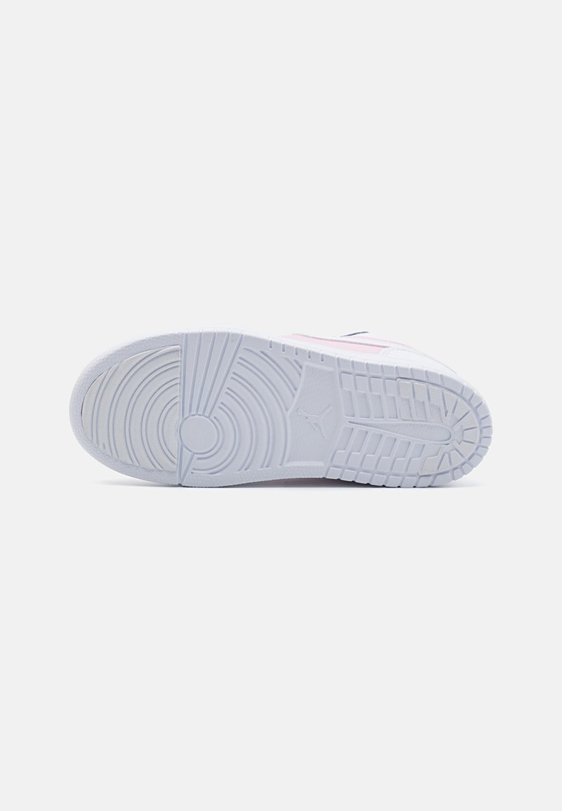 Semelle de sneaker blanche en caoutchouc texturé, présentant un motif à grip circulaire et un logo en relief central. Accentuée par des rayures rose pâle et marine.