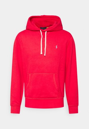 Sweat à capuche rouge avec cordons blancs, poche kangourou à l'avant et petit logo blanc brodé sur le côté gauche de la poitrine.
