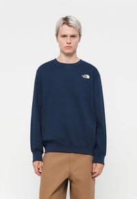 Navy blue sweatshirt with a crew neck, ribbed cuffs, and hem. Features a white logo on the left chest. Made of cotton blend material.