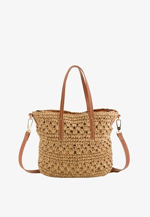 Sac cabas en paille tissée couleur fauve avec anses en cuir marron et bandoulière amovible, présenté avec un motif tissé ouvert texturé.