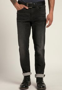 Jeans in denim nero con vestibilità slim, caratterizzati da un classico design a cinque tasche. Orlo risvoltato e abbinati a stivali neri con lacci.