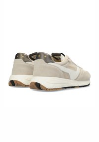 Zapatillas de ante beige con un acento crema, tacón metálico oscuro y tres estrellas doradas. Presenta un logo de marca en blanco y una suela de goma texturizada.