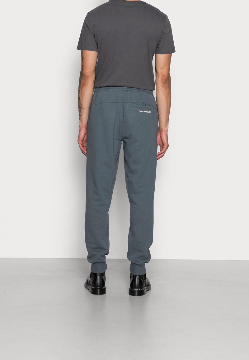 Grau melierte Baumwolljogger mit lockerem Schnitt, elastischem Bund und gerippten Bündchen. Verfügt über ein kleines weißes Logo auf der Gesäßtasche.