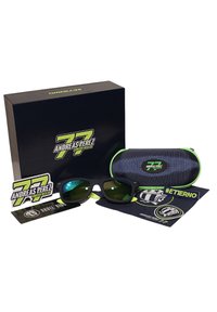 Gafas de sol negras con acentos verdes, empaquetadas en una caja azul marino y un estuche a juego. Incluye pegatinas y un paño de limpieza con logotipos.