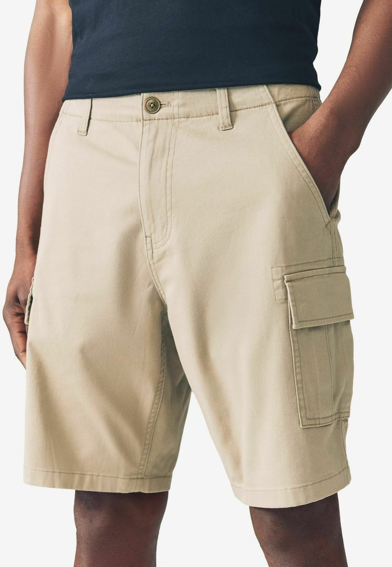 Beige Cargo-Shorts aus Baumwolle, mit seitlichen Taschen, einem vorderen Knopfverschluss und geraden Beinen mit sichtbaren Nähten.