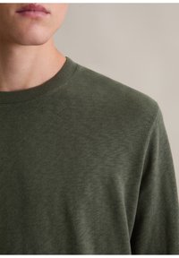 Olivgrüner Rundhalsausschnitt-Pullover, aus weichem Stoff mit glatter Textur. Verfügt über einen gerippten Halsausschnitt und sichtbare Schulternähte.