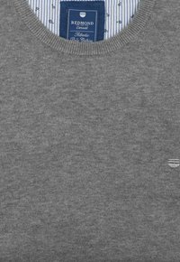Grijze gebreide trui met een ronde hals. Heeft een subtiele textuur en een klein logo op de voorkant. Het label heeft een blauwe achtergrond met witte tekst.