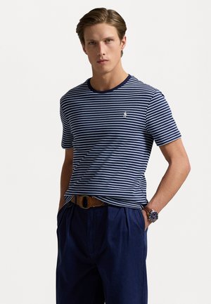 T-shirt a righe navy e bianche con scollo rotondo, dotato di un piccolo logo ricamato sul petto. Il materiale appare liscio e leggero.
