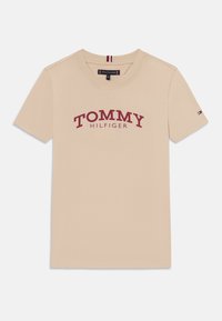 Bežinė medvilninė marškinė su raudonu "TOMMY HILFIGER" logotipu, apvaliu iškirpimu, trumpomis rankovėmis ir mažuoju logotipo akcentu ant rankovės.