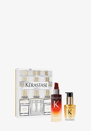 Coffret Kérastase dans une boîte blanche avec une illustration accentuée d'or. Comprend une bouteille de sérum teintée de rouge et une huile dans un flacon transparent avec un couvercle doré.