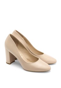 Beżowe skórzane szpilki z okrągłym noskiem i słupkowym obcasem. Wnętrze jest gładkie, bez widocznych wzorów czy okuć.