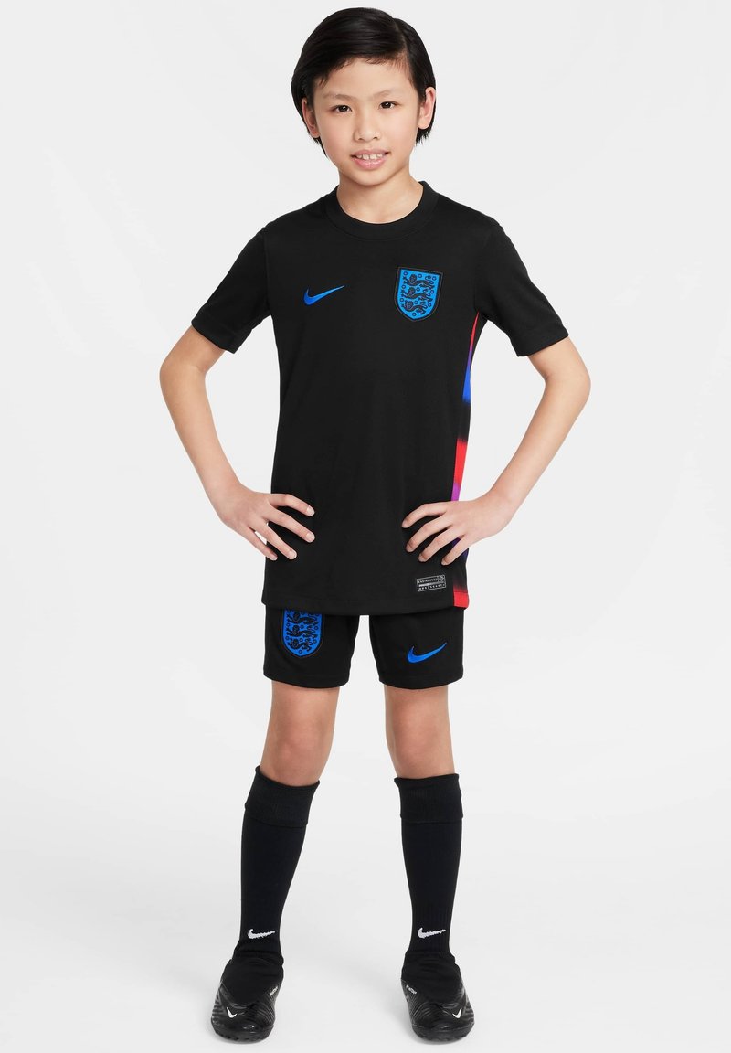 Le kit de football Nike noir comprend un maillot à manches courtes avec des accents bleus et un logo, un short assorti et des chaussettes noires arrivant jusqu'aux genoux.