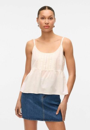 Helles rosa Peplum-Top mit dünnen Trägern, strukturierten Vorderdetails und fließender Silhouette, kombiniert mit einem Jeansrock.