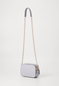 Light lavender crossbody bag with a textured finish, rectangular shape, dual chain and leather strap, gold hardware accents.