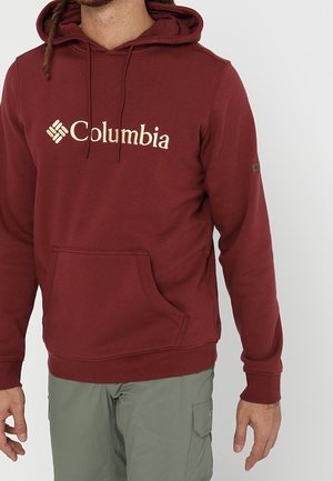 Bordeauxroter Kapuzenpullover mit Fronttasche und gesticktem Columbia-Logo. Verfügt über eine Kapuze mit Kordelzug und gerippte Bündchen.