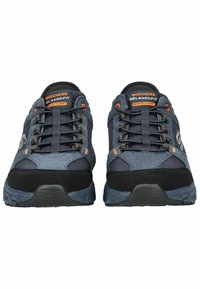 Meeste Skechers Relaxed Fit kingad on varustatud tumesinise ja musta võrgusilmaga ülaservaga, musta kummitaldaga, oranžide aktsentidega ning mäluvahtkattest pehmendusega.