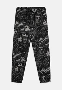 Pantalon de jogging noir avec une variété de graphismes et de textes gris de style cartoon, doté d'une taille élastique et de détails de cordon de serrage.