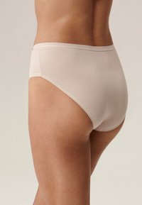 Beżowa bawełniana bielizna hipster z gładką teksturą, wysokim stanem i minimalnymi detalami szwów. Zaprojektowana z myślą o komforcie i dopasowaniu.