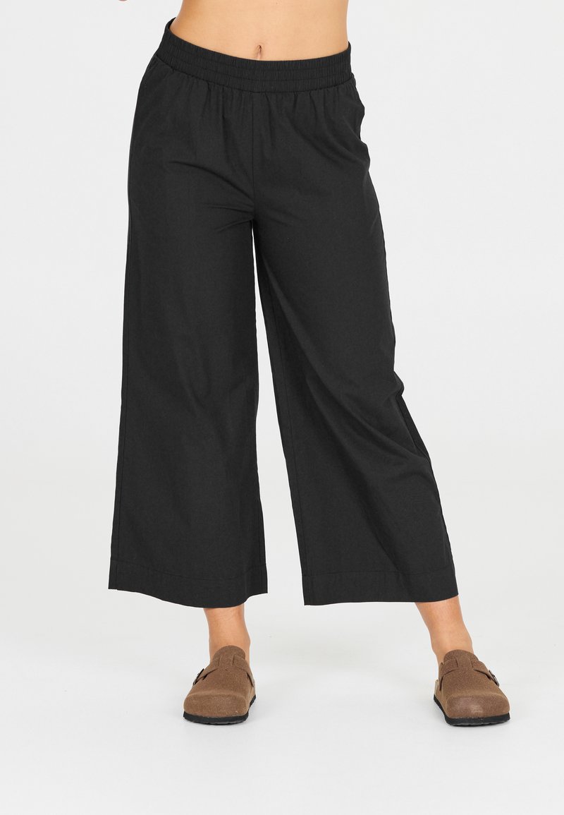 Svarta vida byxor med elastisk midja, tillverkade av lättviktig tyg, med en mjuk textur och ren nederkant.