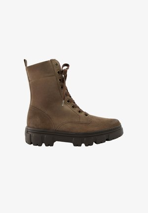 Bota de ante marrón con cordones hasta el tobillo, suela gruesa negra y resistente y lengüeta en la parte trasera.