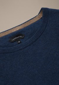 Granatowy sweter o fakturowanej powierzchni, z prążkowanym kołnierzem w jasnobrązowym kolorze. Zawiera czarną metkę z napisem "LANCERTO" oraz rozmiarem "M".
