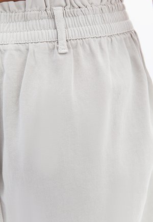 Hellgrauer, strukturierten Stoff mit einem elastischen Bund. Verfügt über eine lockere Passform und ein plissiertes Design für zusätzlichen Komfort. Keine sichtbaren Taschen oder Verzierungen.