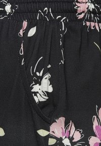 Black fabric with a floral pattern featuring pink and white flowers. Elastic waistband and side pocket detailing, lightweight texture.