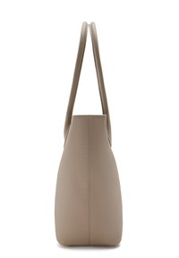 Sac à main en cuir beige avec un design structuré, deux poignées et une texture lisse, se rétrécissant vers la base.