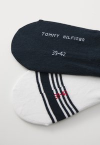 Navy and white ankle socks featuring a ribbed design, with grey and red accents. Size printed as 39-42, brand name "Tommy Hilfiger."