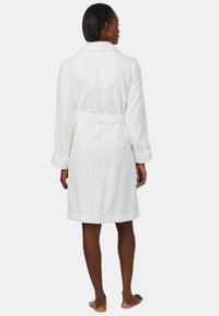 Biały szlafrok wykonany z teksturowanej tkaniny, z kołnierzem szalowym, długimi rękawami i regulowanym paskiem w talii.