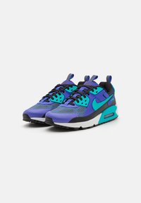 Tenisky Nike s kombinací fialových a tyrkysových materiálů. Mají texturovaný design, černé akcenty a viditelnou vzduchovou výplň.