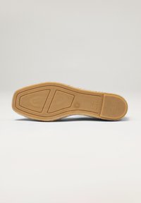 Semelle en caoutchouc avec une texture marron, présentant un motif de semelle multidirectionnel et des détails de marque. Design épuré et minimal.