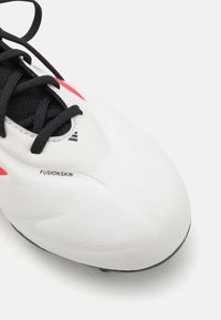 Scarpa da calcio bianca con tomaia sintetica testurizzata, lacci neri e dettagli rossi. Presenta il marchio "FUSIONSKIN" sul lato.