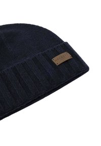 Navy blue knitted beanie with folded ribbed brim and small brown rectangular patch reading "Hackett London" on white background.